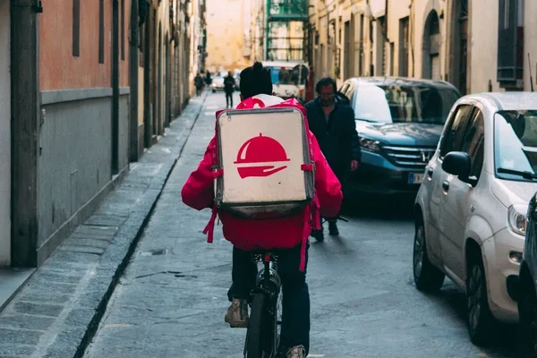 Lieferkurier mit Thermobox auf dem Fahrrad in einer Stadt
